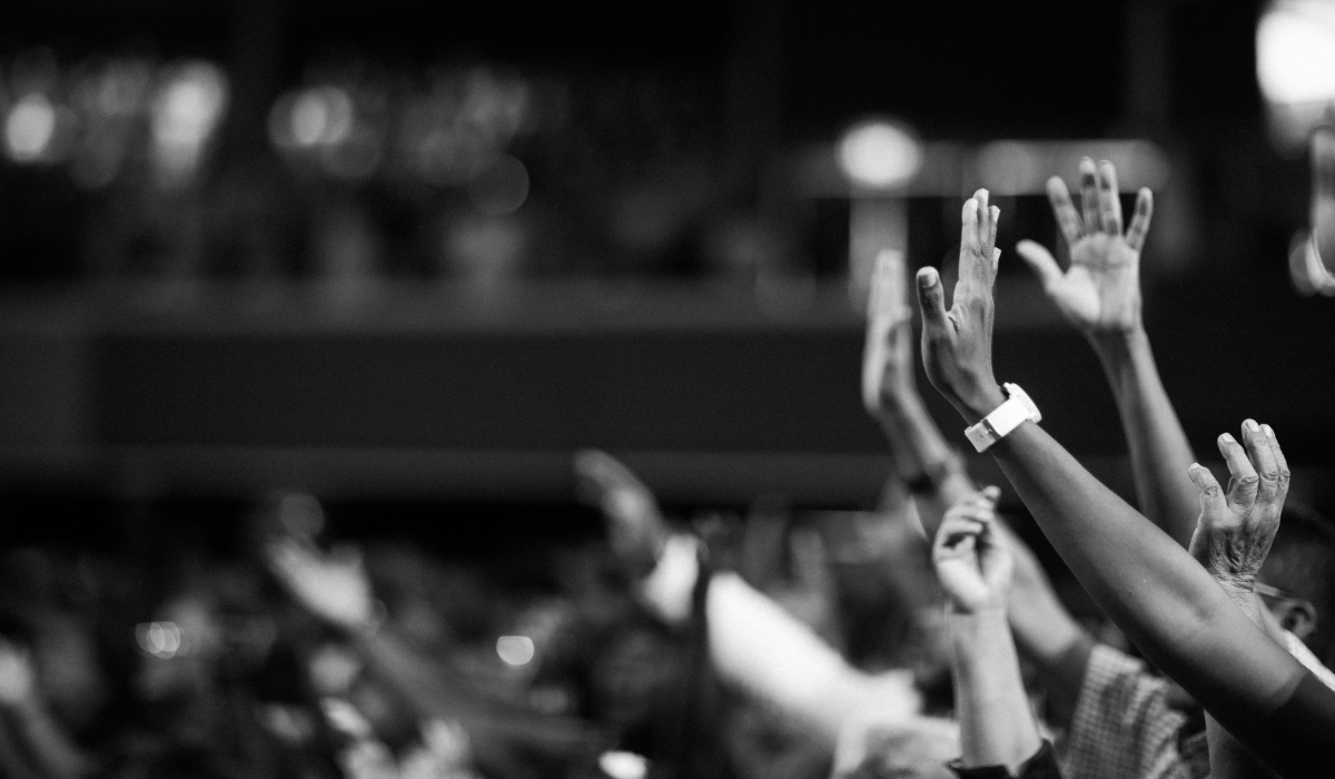 Pessoas com as mãos erguidas durante um culto
